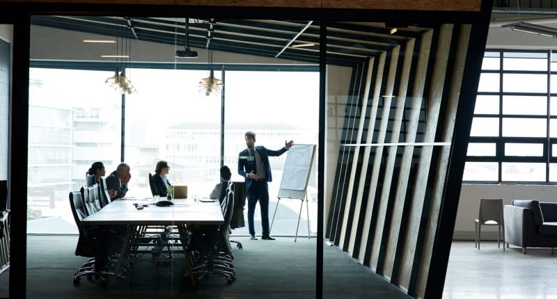 Meeting, presentation and business people in boardroom, planning and feedback for project. Sales team, coworkers and group in modern office, brainstorming and review for kpi target and market value.