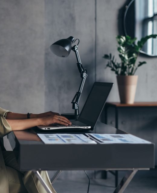Woman works at home sitting at her desk with her laptop